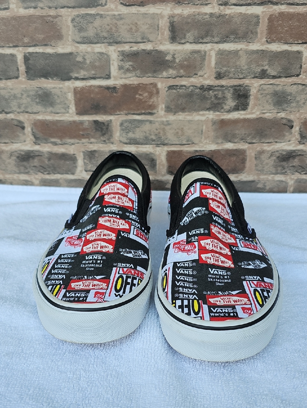 Vans Slip-On Sneakers in Black, White & Red Logo Patch Print